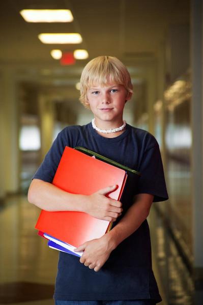 boy holding books in hallway